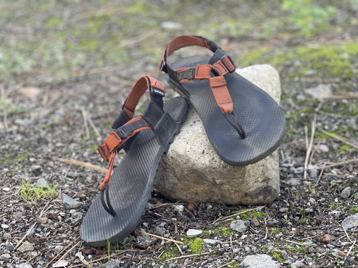 A medium shot of two sandals propped against a rock