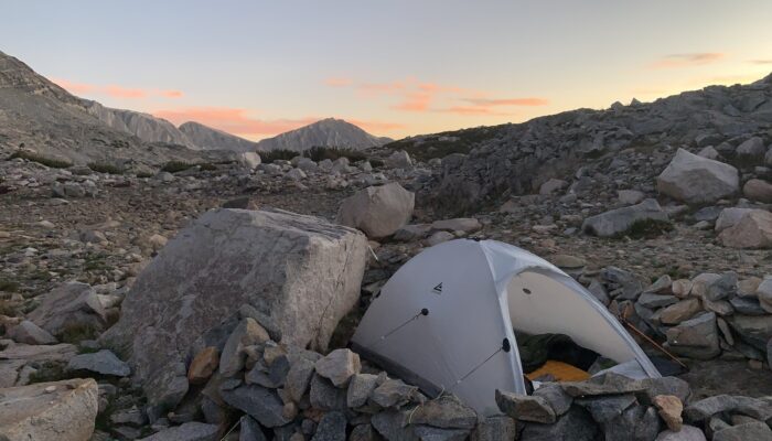 a white tent sitting on top of a pile of rocks
