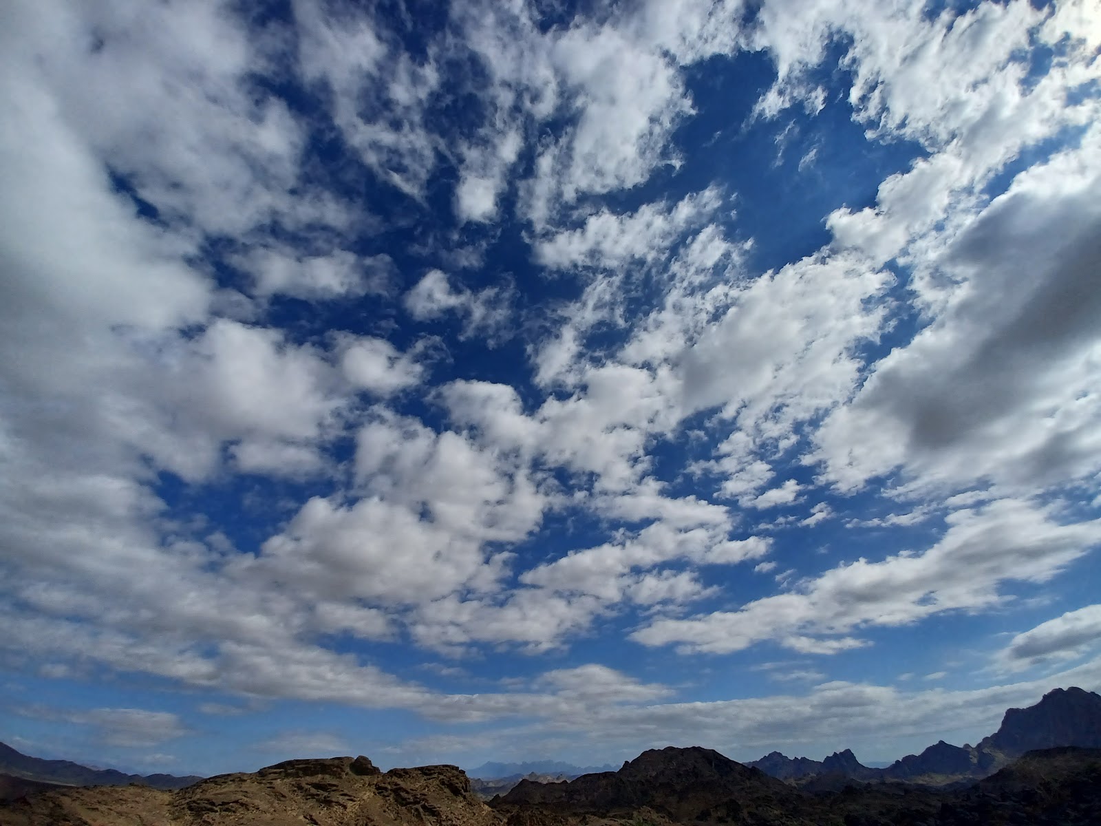 a view of a mountain range with clouds in the sky