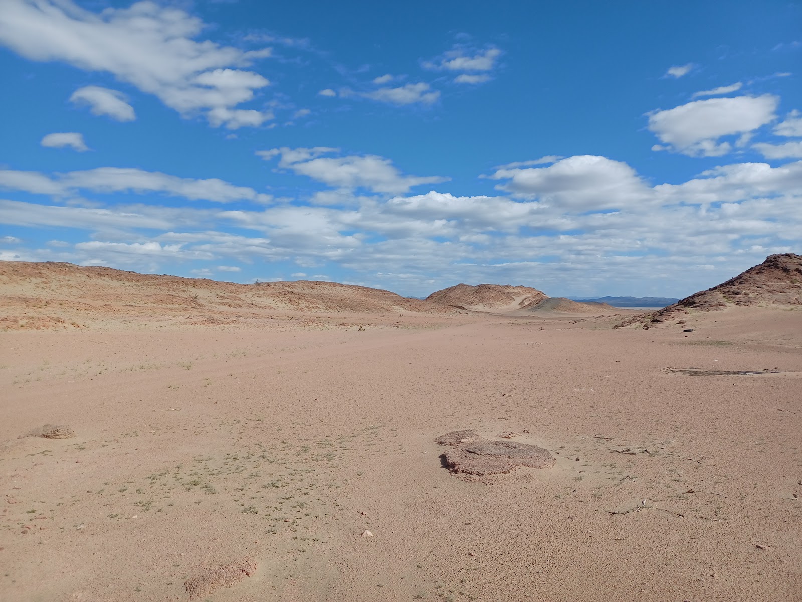 a desert landscape with a few clouds in the sky