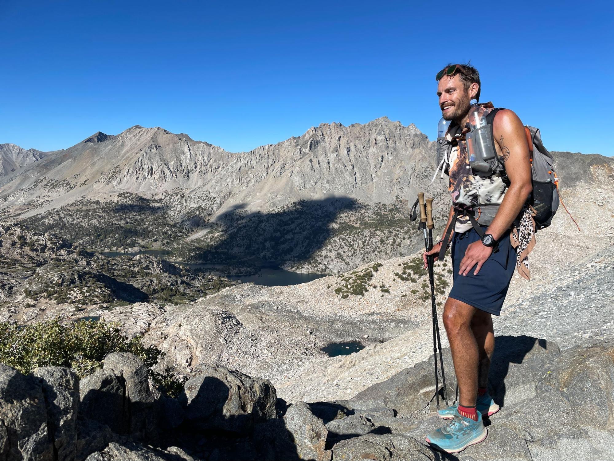 a man standing on top of a mountain with a backpack