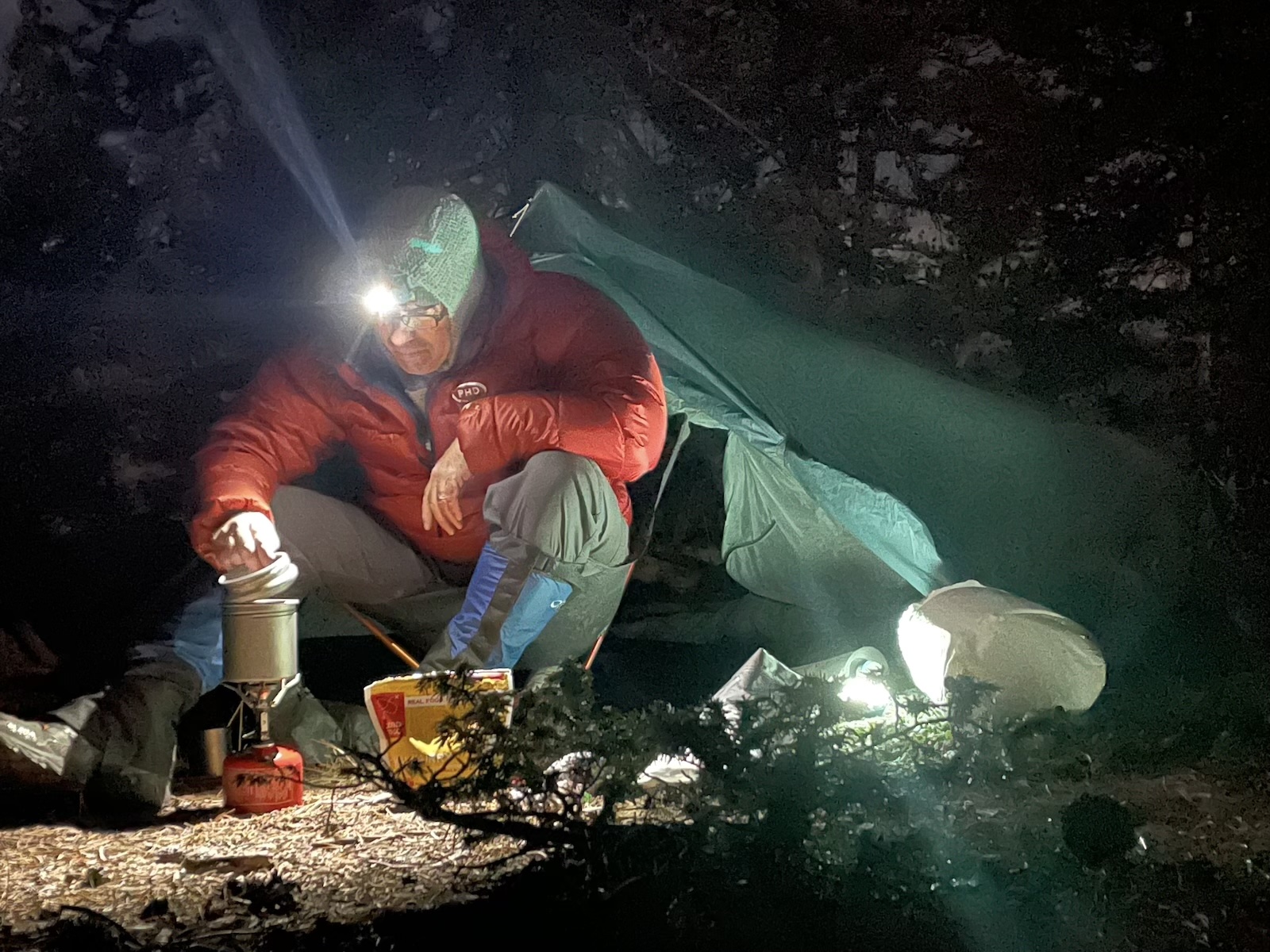 a man sitting in a tent with a flashlight