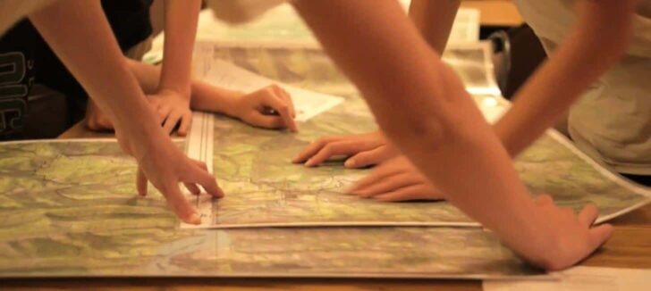 a close-up of hands pointing to maps