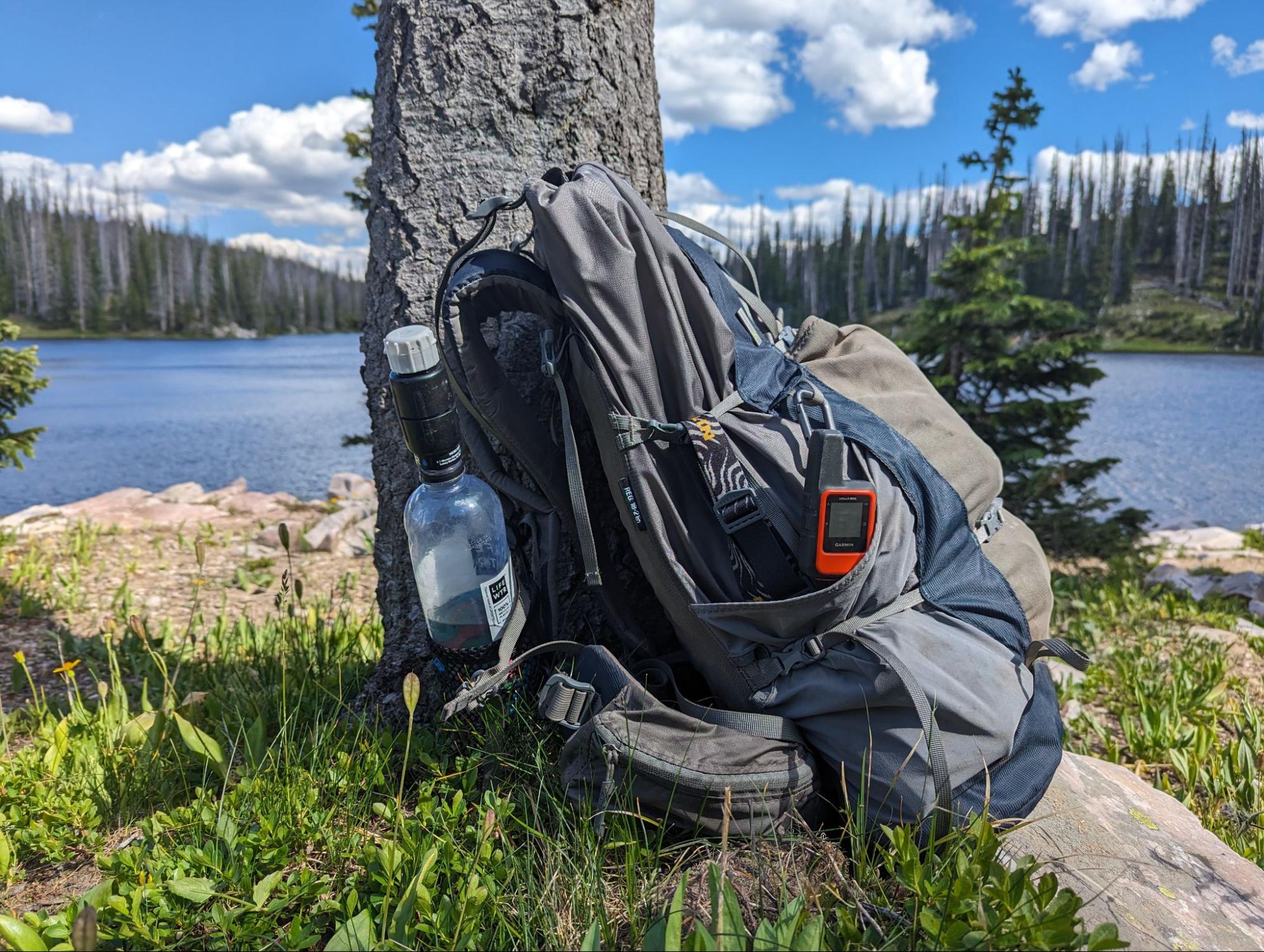 a backpack sitting on the ground next to a tree