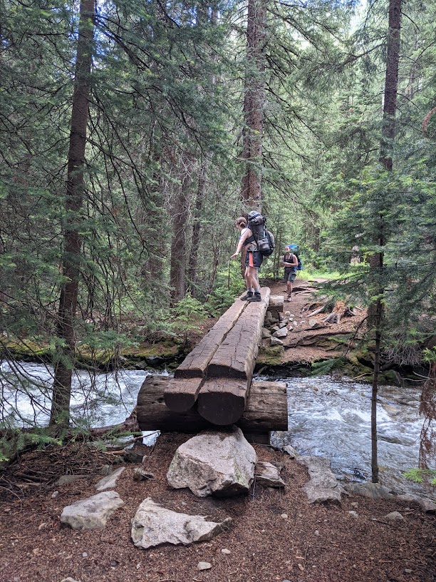 a man riding a bike across a wooden bridge