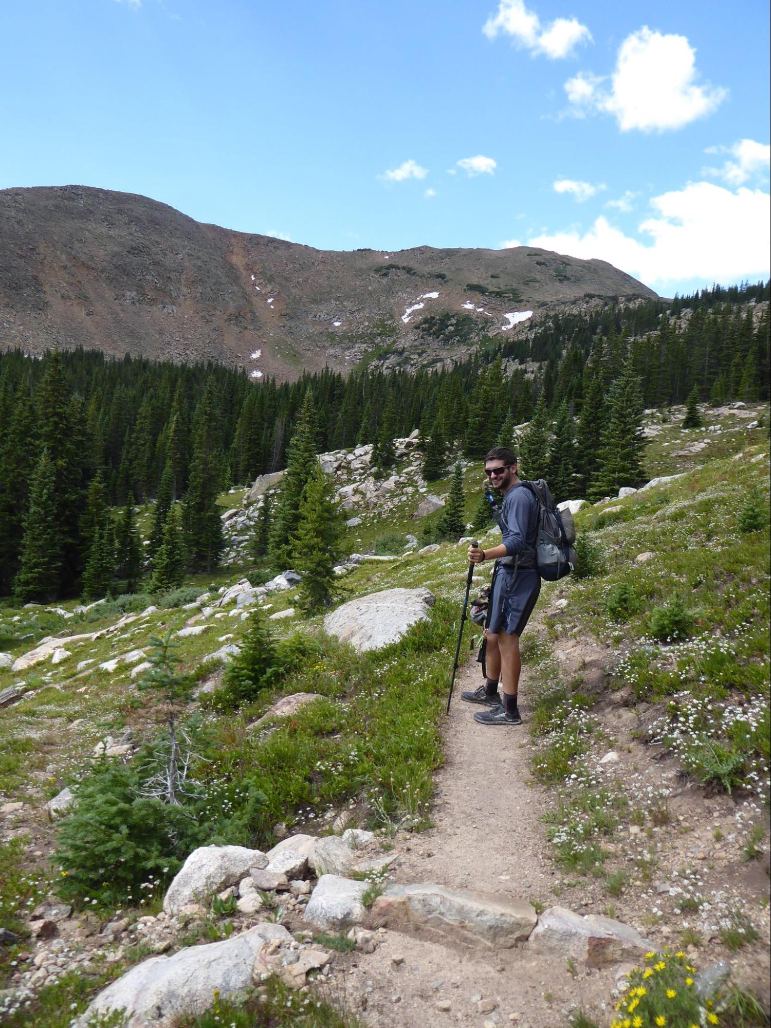 a man hiking up a trail in the mountains