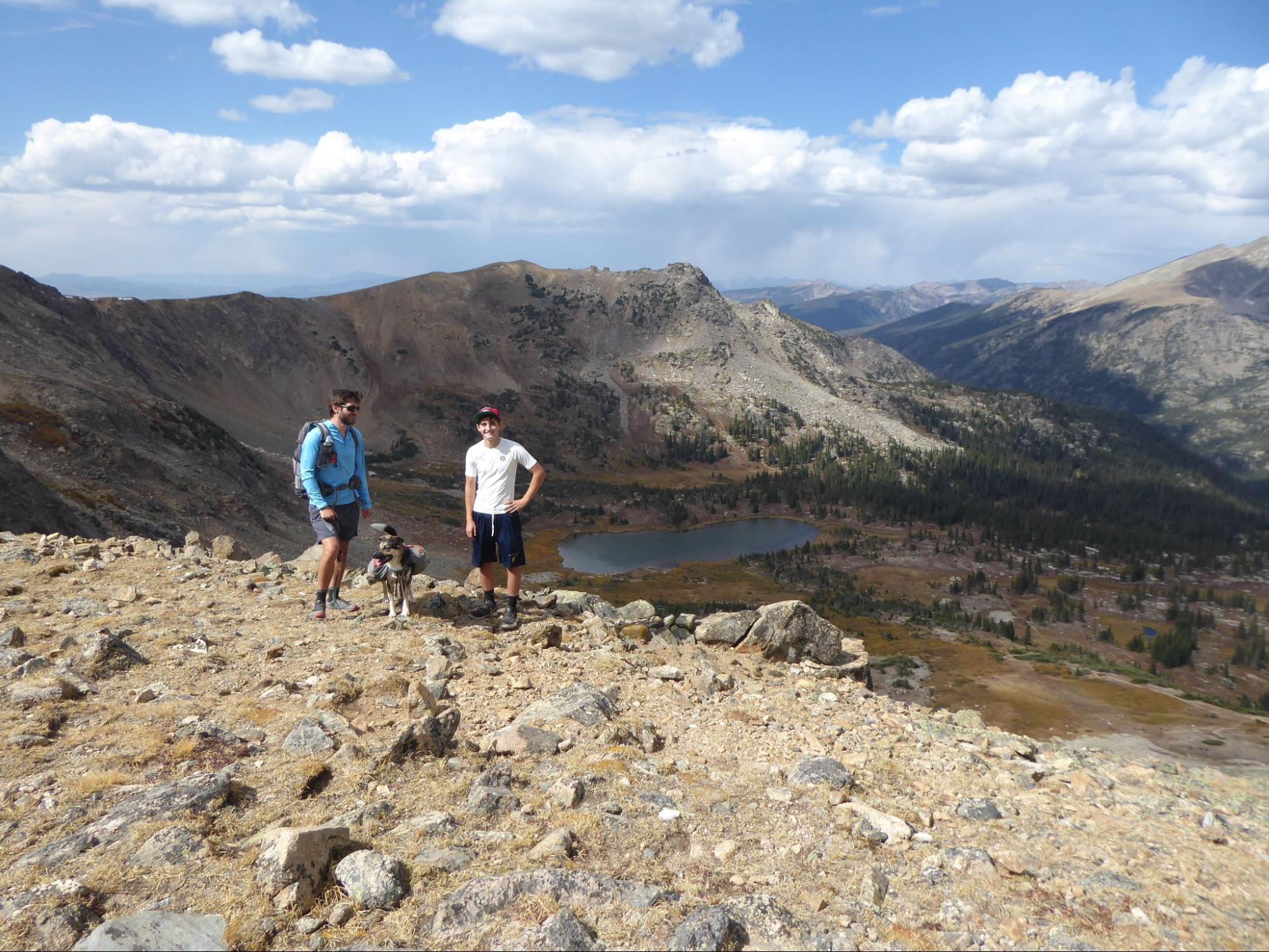 a couple of men standing on top of a mountain