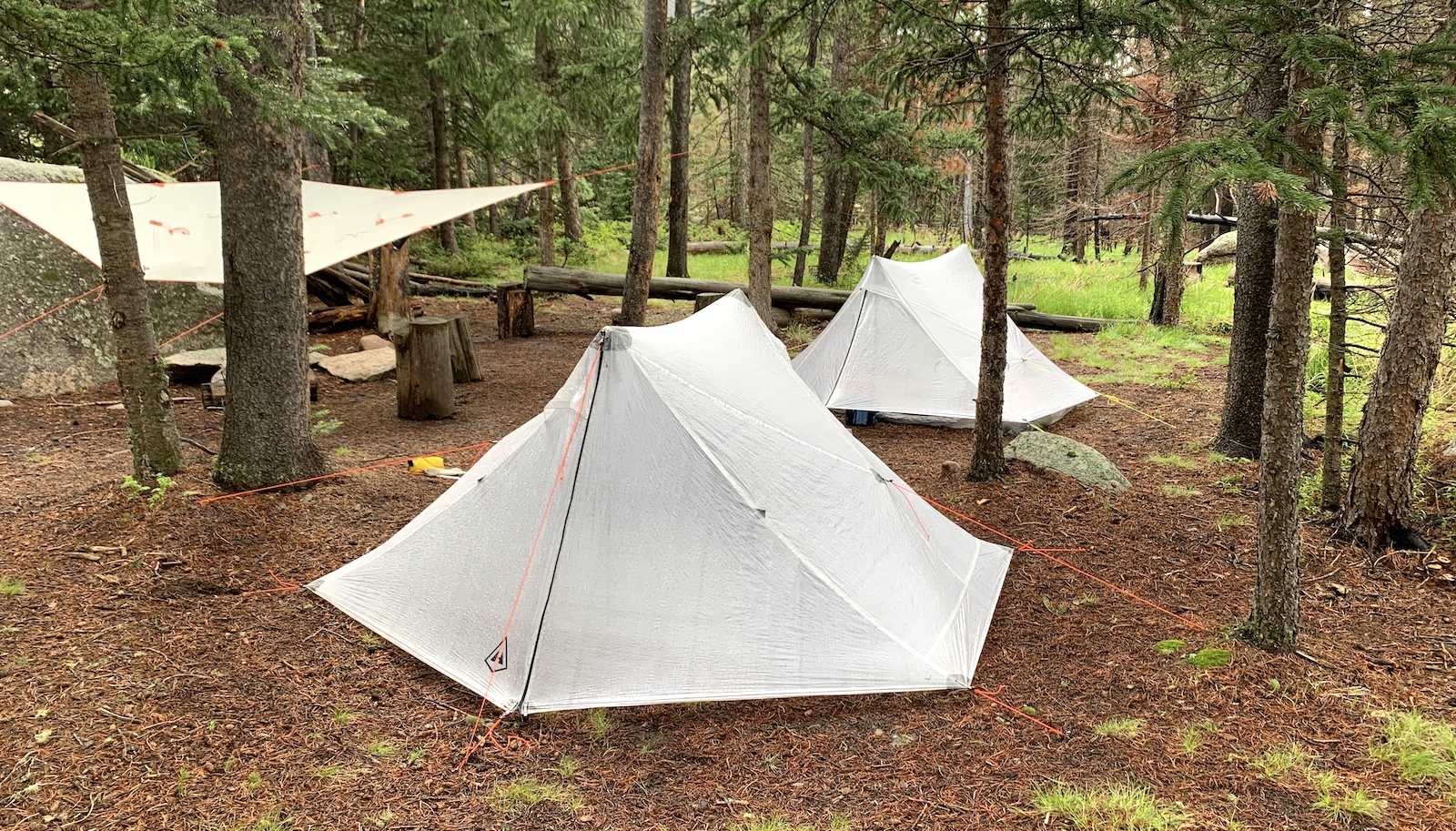 a couple of tents sitting in the middle of a forest