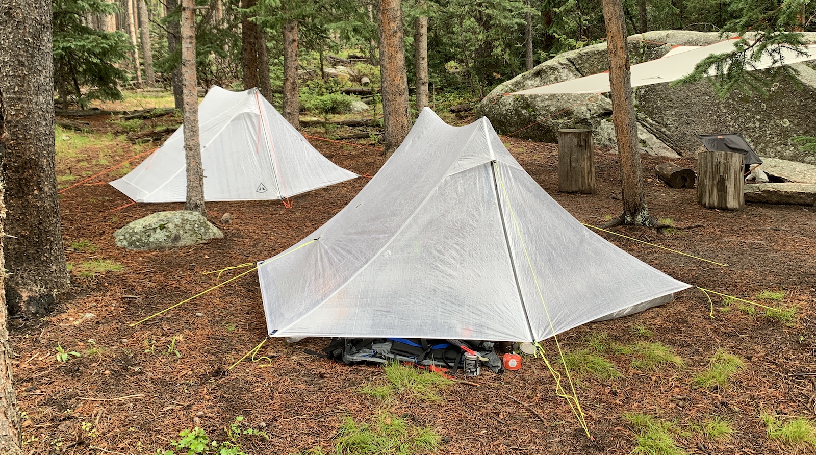 a couple of tents sitting in the middle of a forest