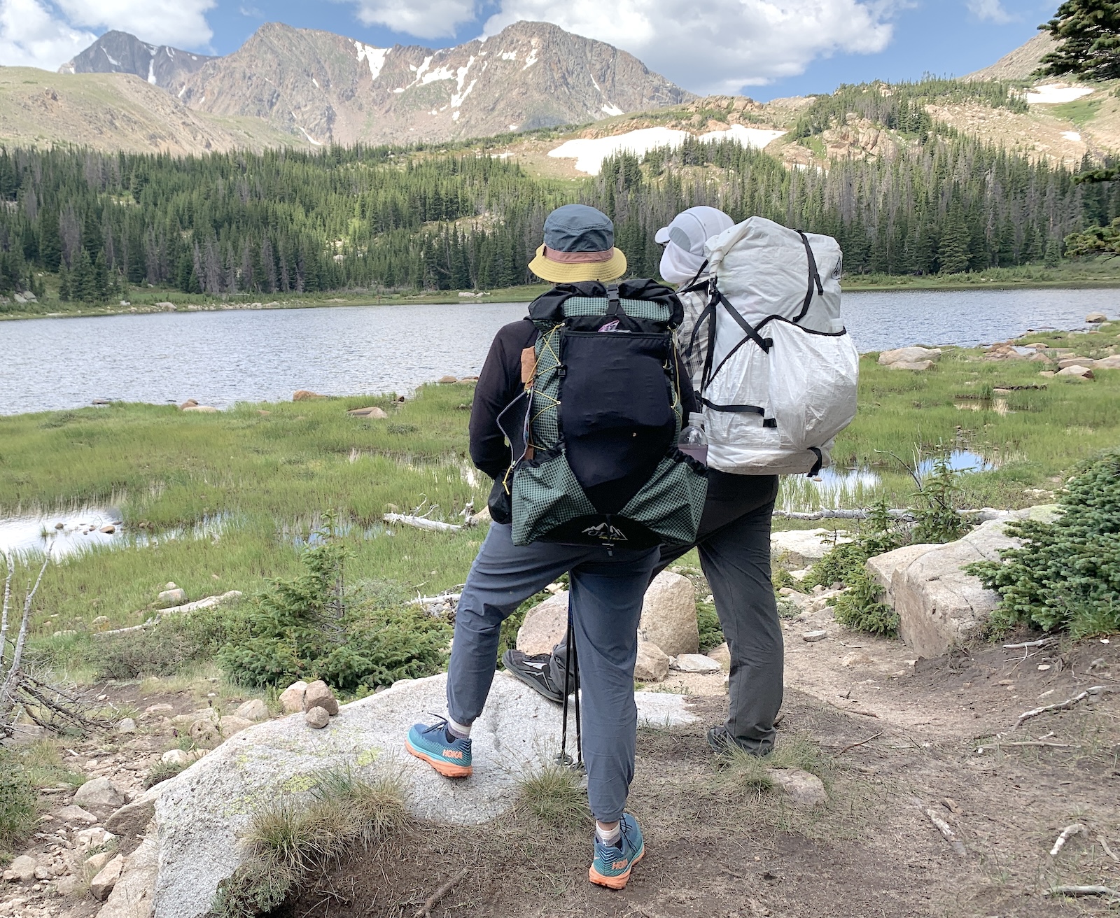 a couple of people with backpacks walking up a hill