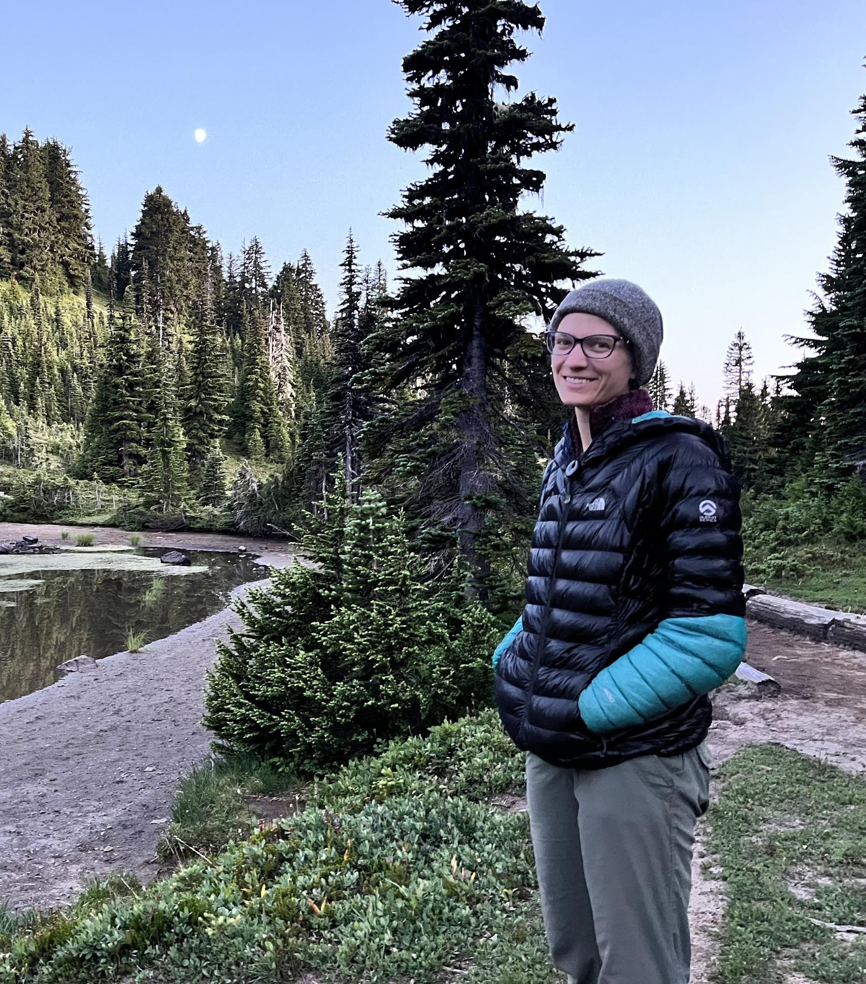 a woman standing in front of a body of water