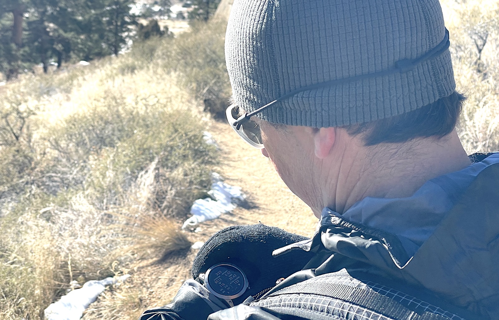 a man in a hat and jacket looking out over a field