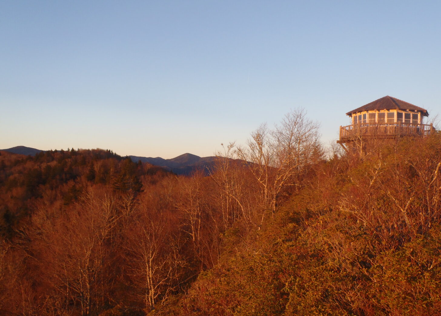 A lookout tower with mountains in the background.
