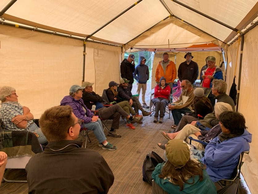 a group of people sitting inside of a tent