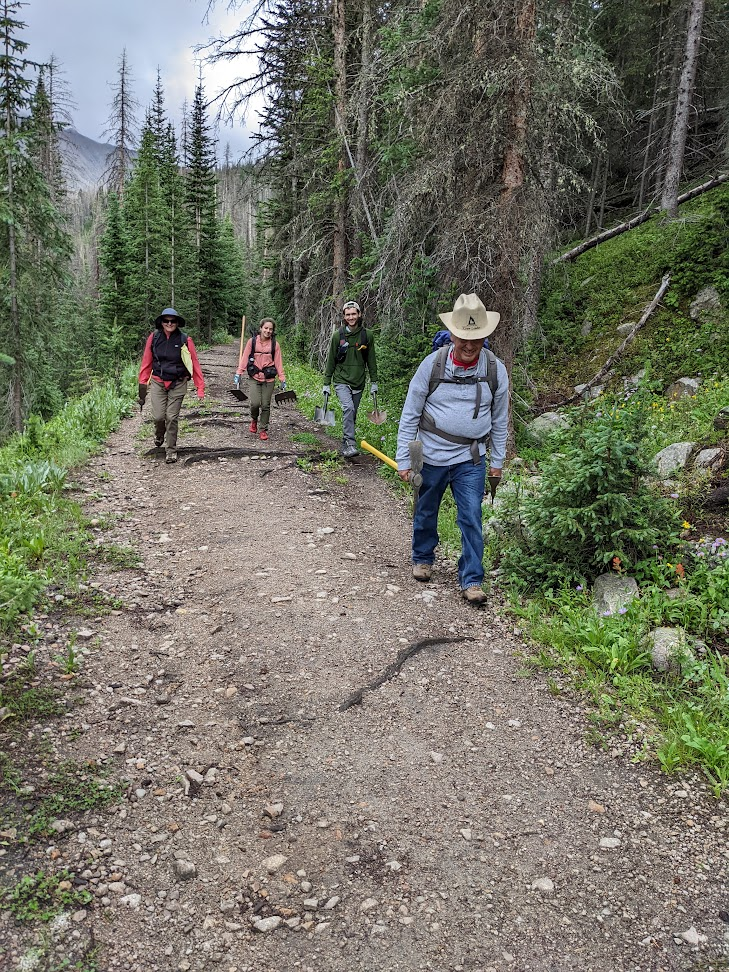 a group of people walking down a dirt road