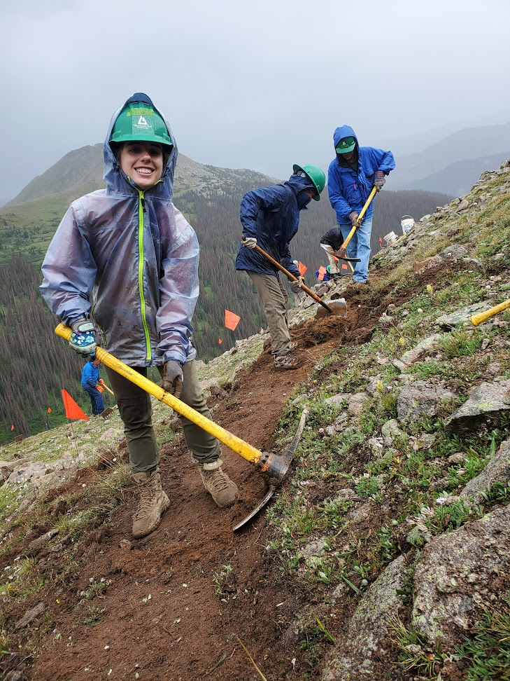 a group of people with shovels on top of a hill