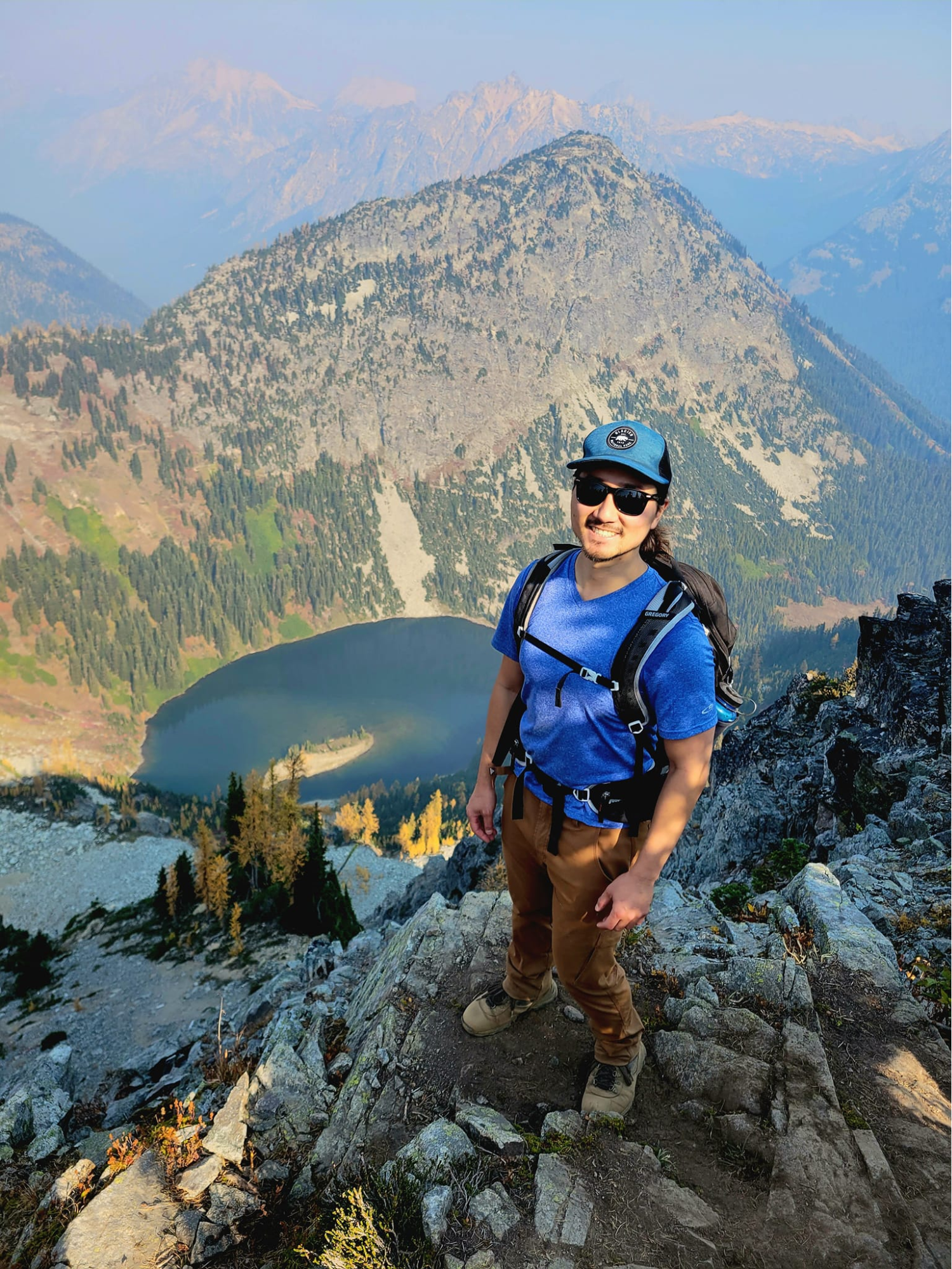 a man standing on top of a mountain with a backpack