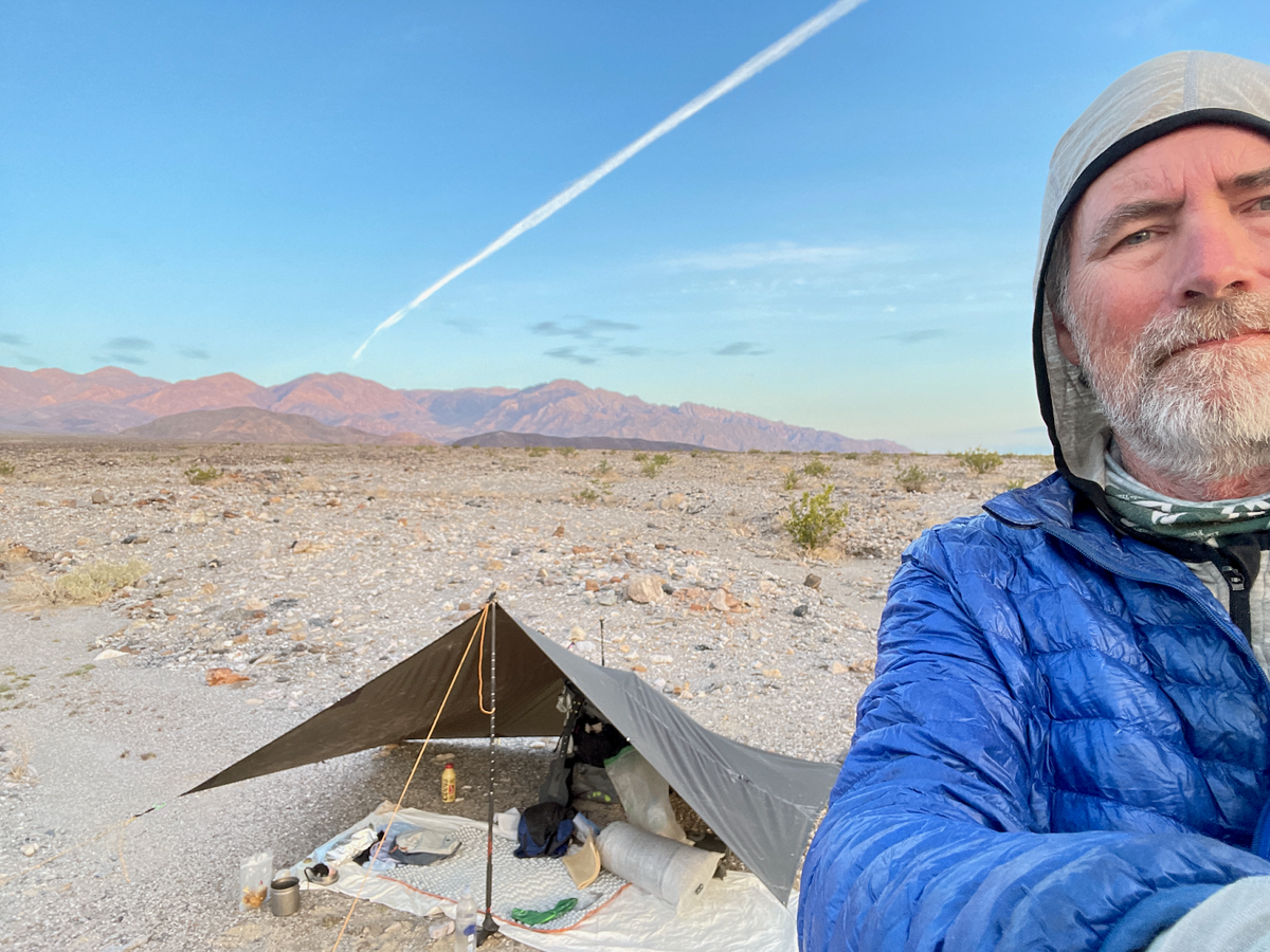 a man sitting in a tent in the desert